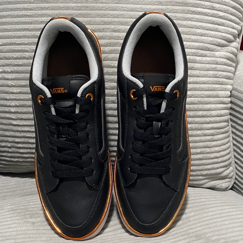 V A N S Men's Black Leather Sneakers with golden orange trim and VANS logo.